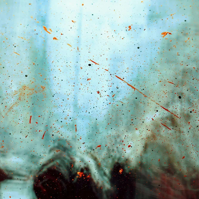 Abstract image of a misty window with splatters of red paint. 
